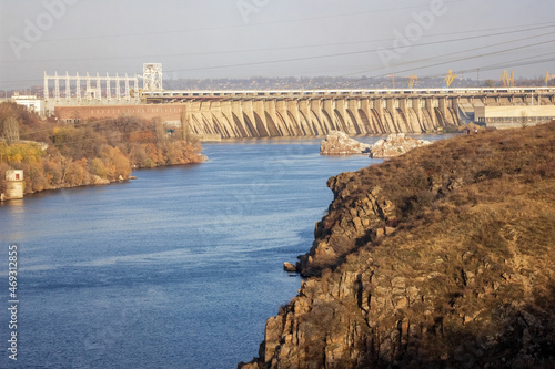 View of the hydroelectric dam across the Dnieper river on a sunny day in autumn. Zaporozhye city, Ukraine. Local landmark photo