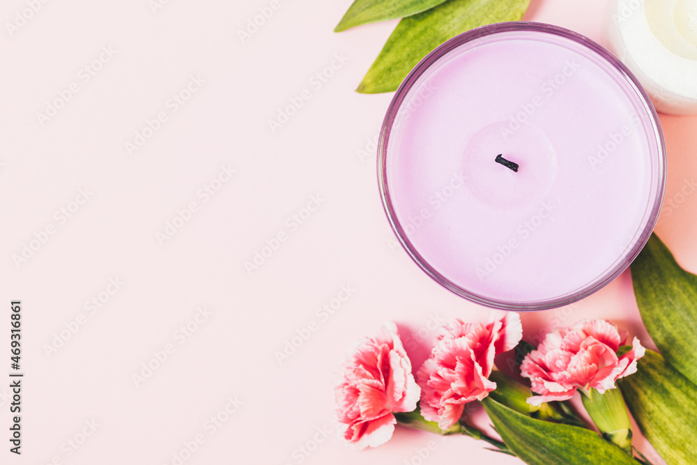Aroma candle lilac color next to fresh flowers Aroma candle lilac color next to fresh flowers