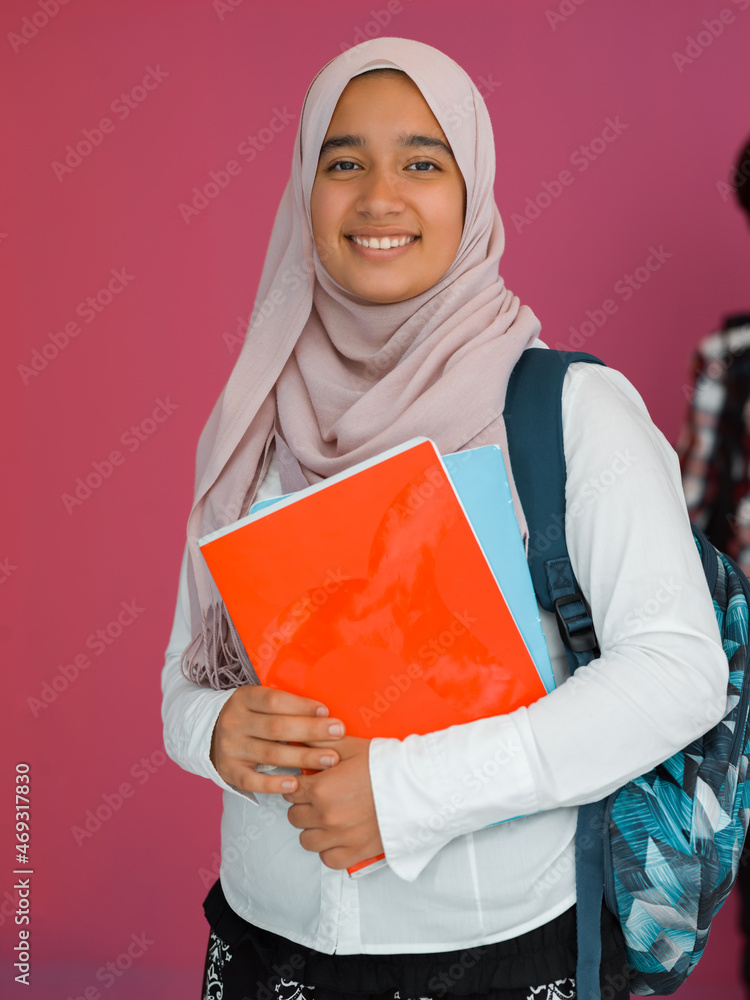 A group of Arab teenagers, a student team walking forward into the future and back to school the concept of a pink background. The concept of successful education for young people. Selective focus A group of Arab teenagers, a student team walking forward into the future and back to school the concept of a pink background. The concept of successful education for young people. Selective focus