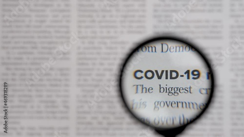 Health news text covid 19 newsletter through lens magnifying loupe. Read newspaper article headline covid news letter. Newspaper headline news coronavirus pandemic information search magnifier glass