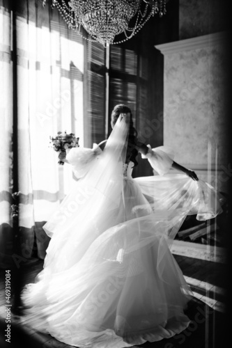 the bride in a beautiful white dress is spinning in the studio black and white photo