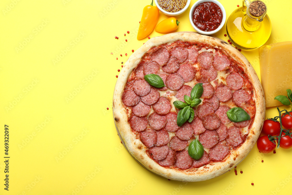 Concept of tasty food with Salami pizza on yellow background Concept of tasty food with Salami pizza on yellow background