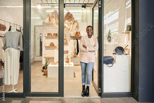 Smiling African American female entrepreneur standing at her shop door