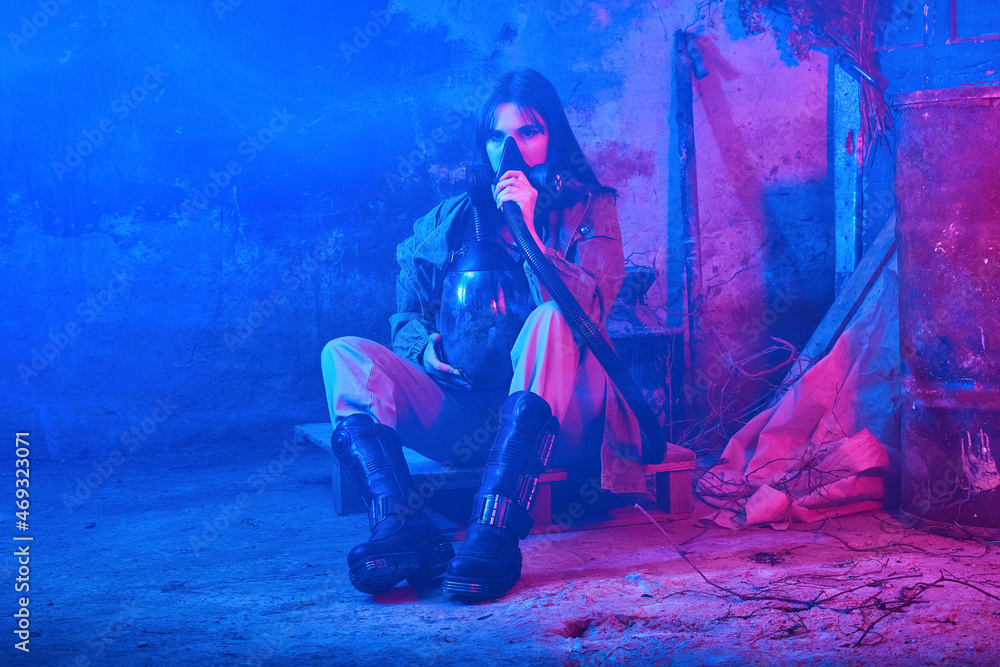 Obraz premium girl with respirator in neon light in an abandoned building. concept
