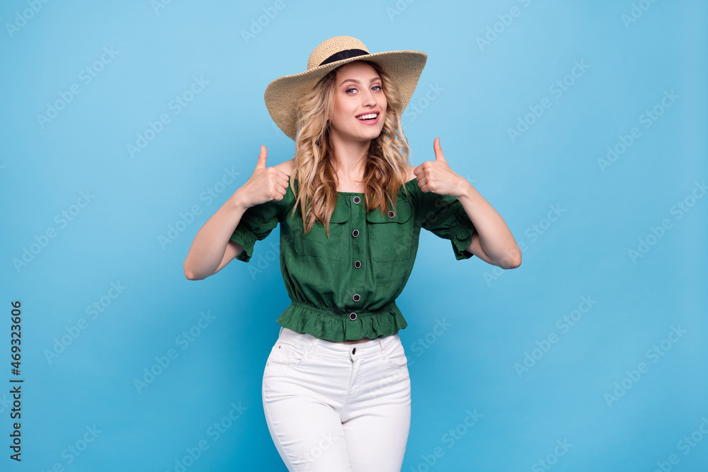 Photo of reliable lady raise two thumbs up wear straw hat bear shoulders green blouse isolated blue color background Photo of reliable lady raise two thumbs up wear straw hat bear shoulders green blouse isolated blue color background