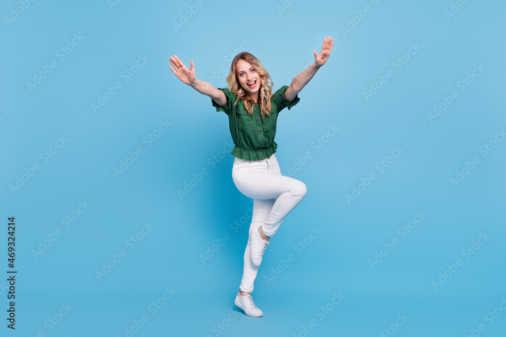 Photo of cheerful excited lady raise hands wear bear shoulders green blouse isolated blue color background