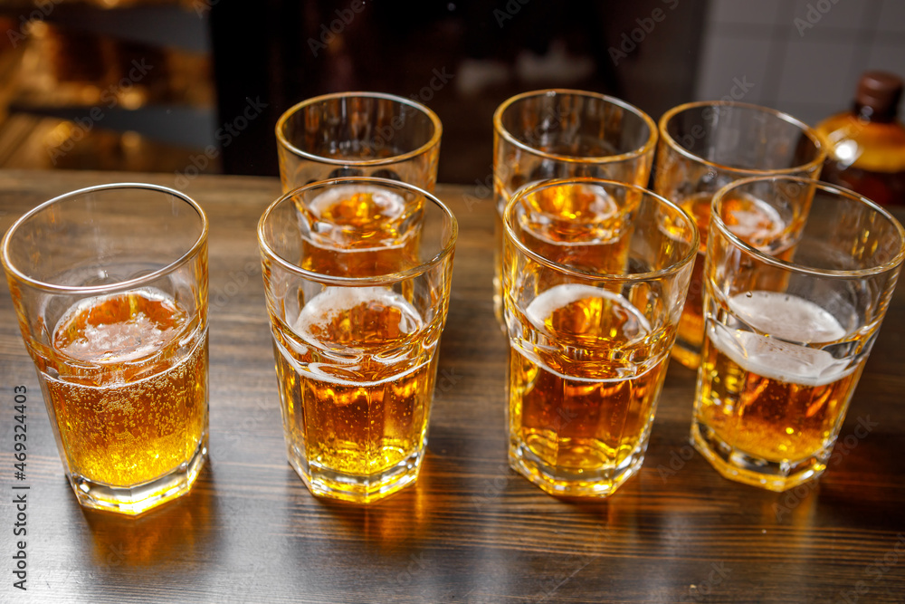 Glasses of beer are in the bar on the bar counter. Glasses of beer are in the bar on the bar counter.