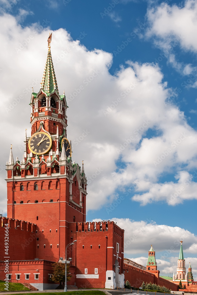 Spasskaya Tower of the Moscow Kremlin. Moscow chimes against the background of a blue sky with clouds. Spasskaya Tower of the Moscow Kremlin. Moscow chimes against the background of a blue sky with clouds.