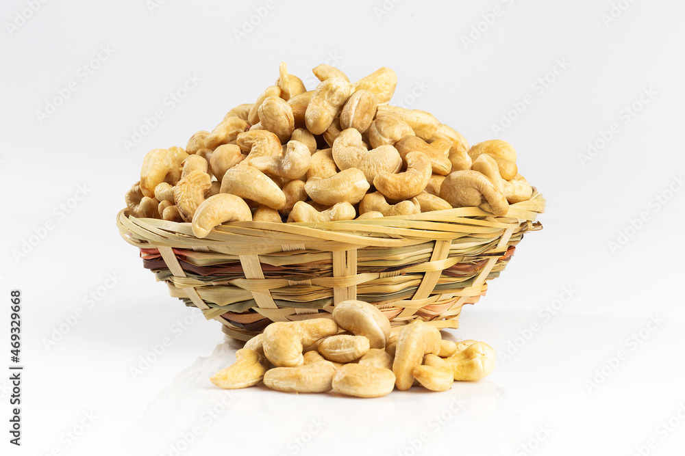 Cashew nuts in a wicker bowl. Isolated on white. Cashew nuts in a wicker bowl. Isolated on white.