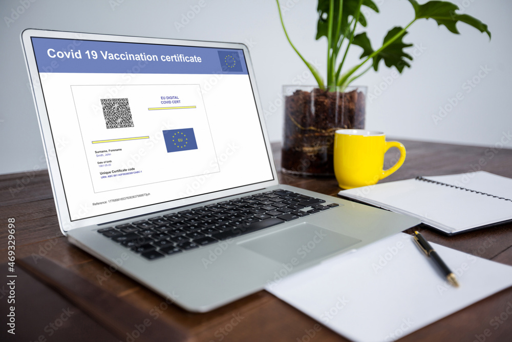 Fototapeta premium Laptop with covid vaccination certificate and qr code on screen