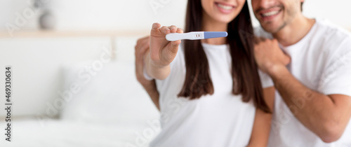 Unrecognizable happy young caucasian male and lady rejoice result and show pregnancy test