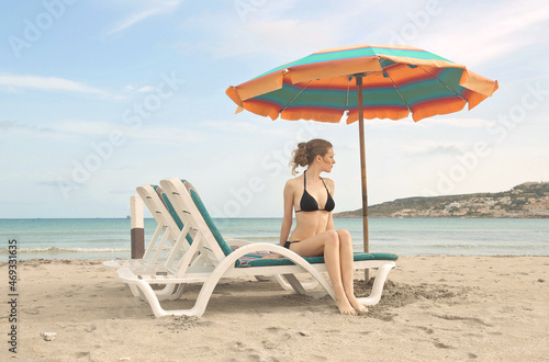 young woman sitting on a deckchair at the beach