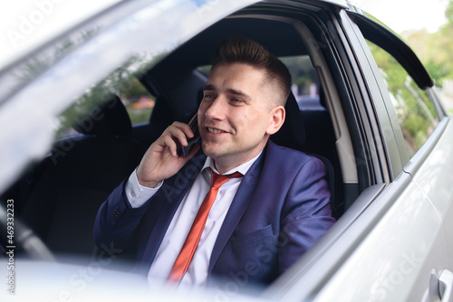 A male business man is talking on the phone in a car. © fotofrol