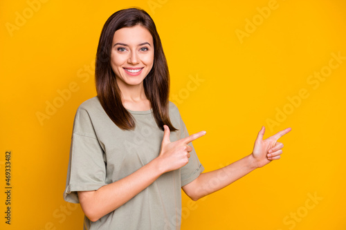 Photo of young lovely pretty happy positive smiling cheerful girl pointing fingers copyspace isolated on yellow color background