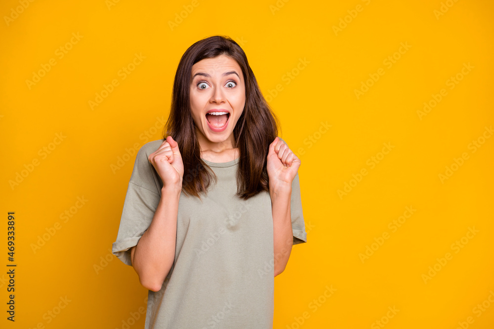 Photo of young happy excited smiling cheerful shocked amazed girl win lottery isolated on yellow color background Photo of young happy excited smiling cheerful shocked amazed girl win lottery isolated on yellow color background