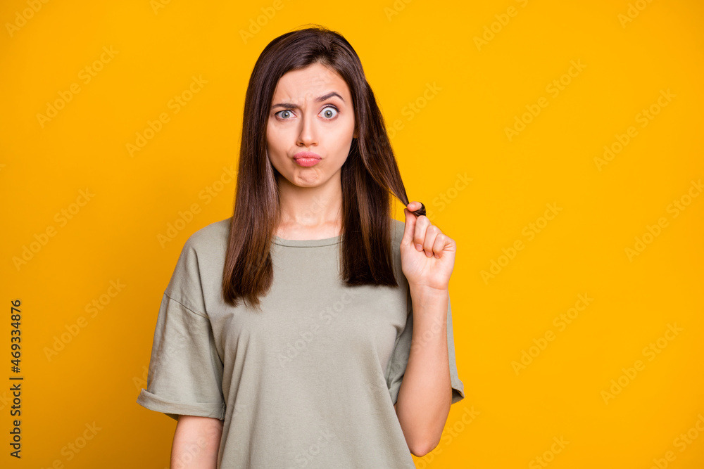 Photo of young funky funny uncertain shocked skeptic unsure girl pout lips pull hair isolated on yellow color background Photo of young funky funny uncertain shocked skeptic unsure girl pout lips pull hair isolated on yellow color background