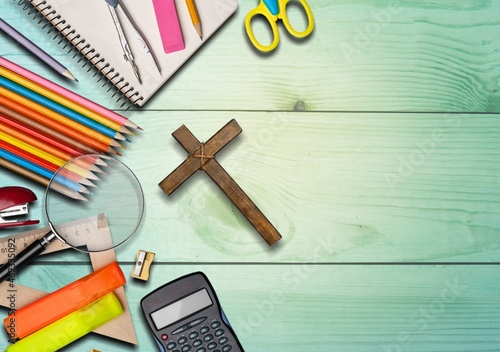 Office or school supplies with Christian cross on the desk photo