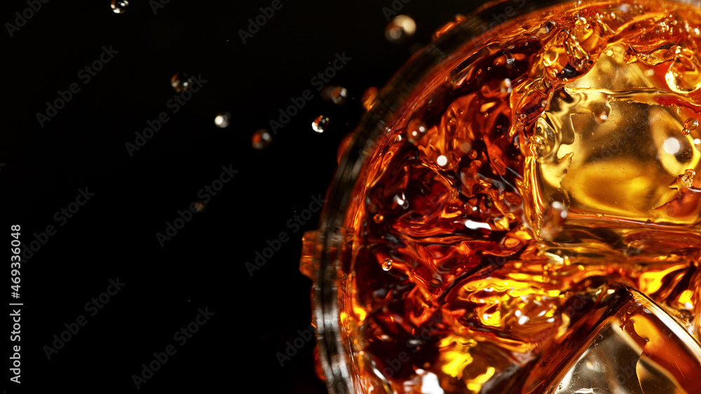 Top shot of whisky glass with ice cubes, closeup.