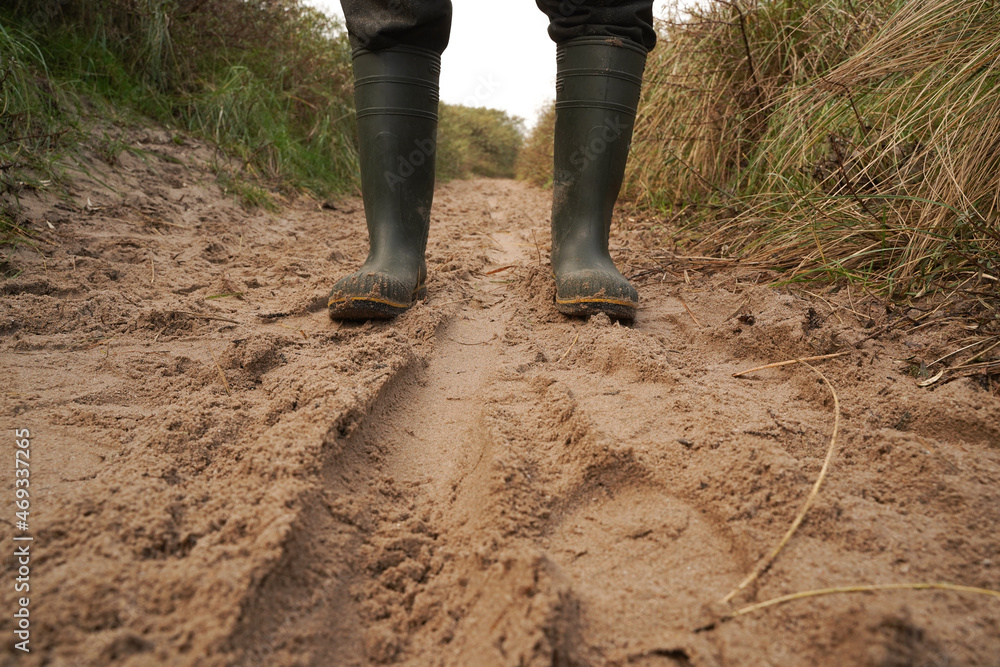 Boots on a sandy path through the dunes Boots on a sandy path through the dunes