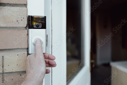 Slika na platnu Shallow focus of a homeowner seen testing a newly installed WiFi smart doorbell