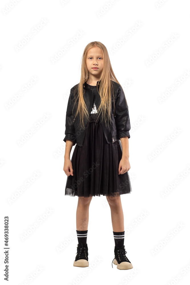 A full-length portrait of a young girl with long brown hair dressed in a hooligan style. A full-length portrait of a young girl with long brown hair dressed in a hooligan style.