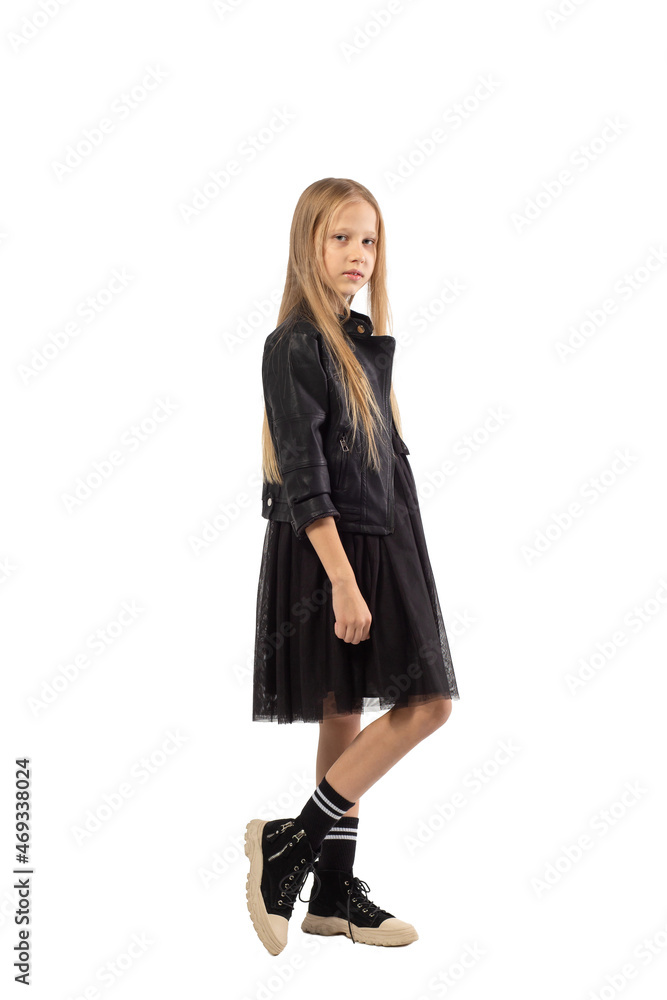 A full-length portrait of a young girl with long brown hair dressed in a hooligan style. A full-length portrait of a young girl with long brown hair dressed in a hooligan style.