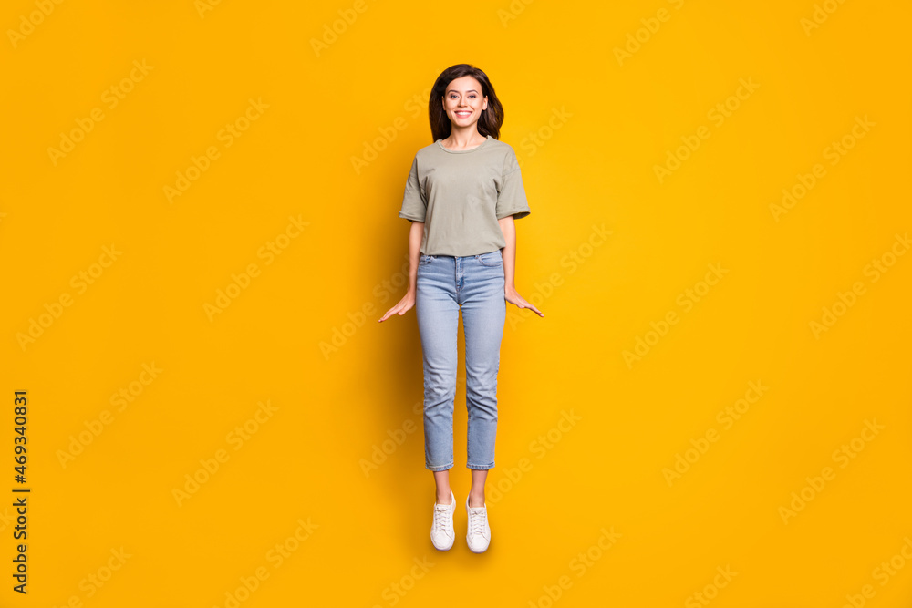 Full length body size view of pretty funny cheerful skinny girl jumping having fun isolated over bright yellow color background Full length body size view of pretty funny cheerful skinny girl jumping having fun isolated over bright yellow color background
