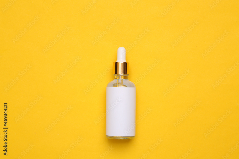 Mockup serum bottle on yellow background. Creative trendy beauty flat lay Mockup serum bottle on yellow background. Creative trendy beauty flat lay