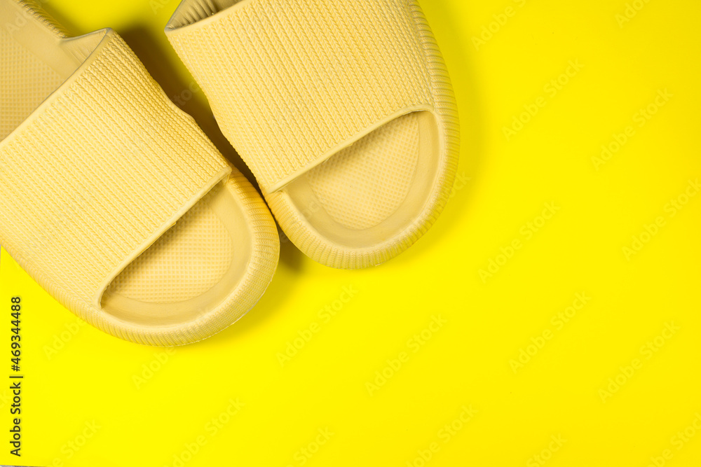 Yellow Summer Slippers on the yellow background. Pair of house indoors shoes. Minimalist, creative photo. Yellow Summer Slippers on the yellow background. Pair of house indoors shoes. Minimalist, creative photo.