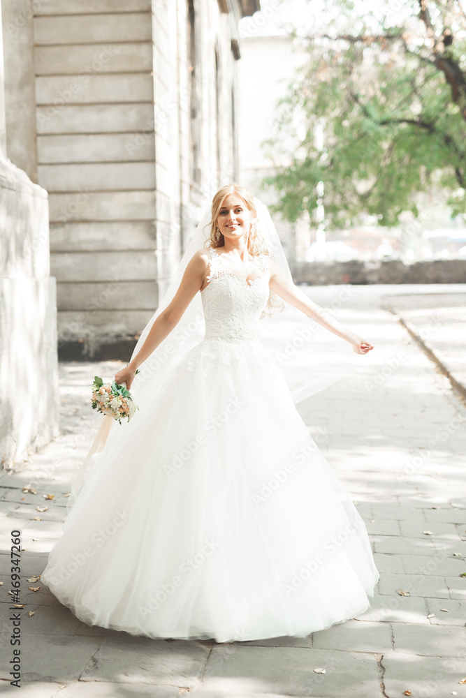 Beautiful bride spinning with perfect dress in the park