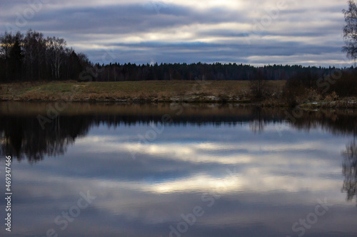 Forest reflection in water surface. Colors frame: yellow, blue, green. 