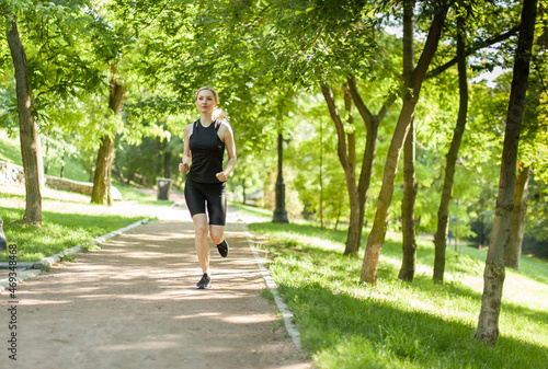 Young blonde woman jogging in the park