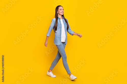 Full body profile side photo of young adorable lady go wear casual outfit look empty space isolated over yellow color background
