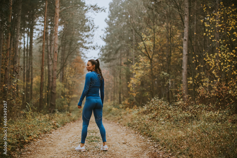 Young woman take a break during outdoor exercise on the forest trail at autumn Young woman take a break during outdoor exercise on the forest trail at autumn