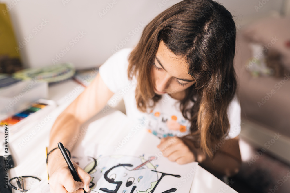 Teenage girl colouring on a poster board the figure of not exceeding the increase of the earth's temperature by more than 1.5 degrees Celsius in the next decade. Social demand for future generations Teenage girl colouring on a poster board the figure of not exceeding the increase of the earth's temperature by more than 1.5 degrees Celsius in the next decade. Social demand for future generations