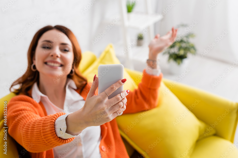 blurred woman smiling and gesturing while taking selfie on mobile phone blurred woman smiling and gesturing while taking selfie on mobile phone