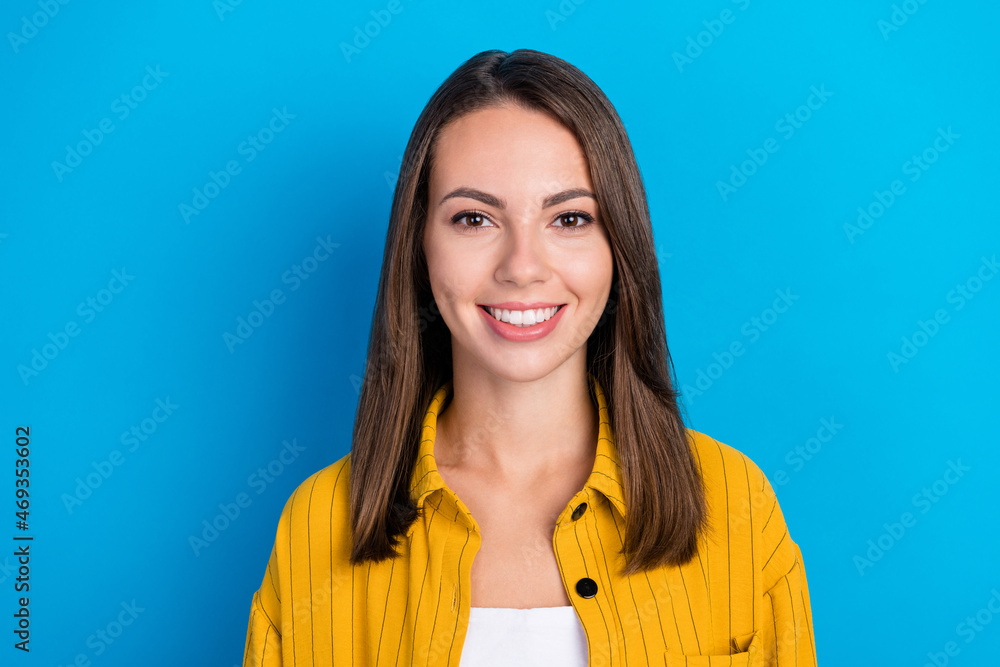 Photo of optimistic young brunette lady wear yellow shirt isolated on blue color background Photo of optimistic young brunette lady wear yellow shirt isolated on blue color background