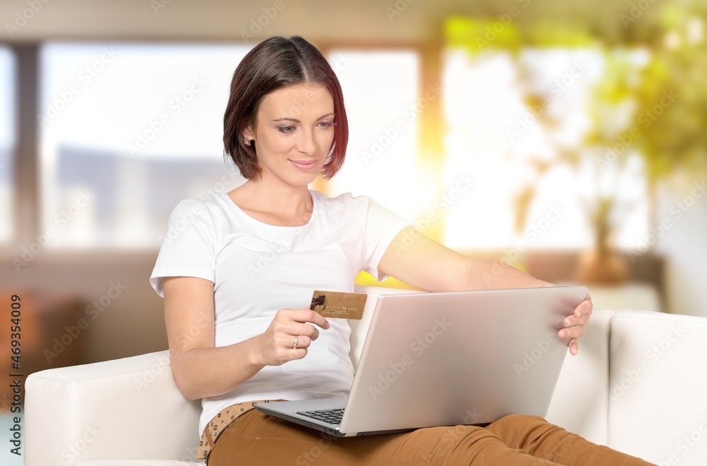Happy young woman shopping online, paying bills with credit card Happy young woman shopping online, paying bills with credit card