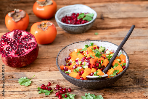 Persimmon Salsa. Healthy vegetarian bowl salad with Persimmon, pomegranate, cucumber, onion and cilantro.