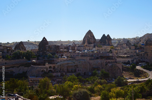Panoramic landscape view of Turkish city Goreme with vintage buildings and cave houses at sunny autumn morning. Fabulous landscapes of the mountains and spectacular rocks formations of Cappadocia