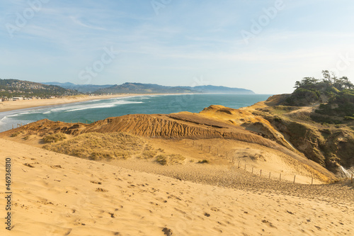 Sandy  hilly coast of the ocean. A blue streak of water can be seen in the distance. Modest low-key nature. No people. Calm scenes  recreation tourism  travel  ecology.