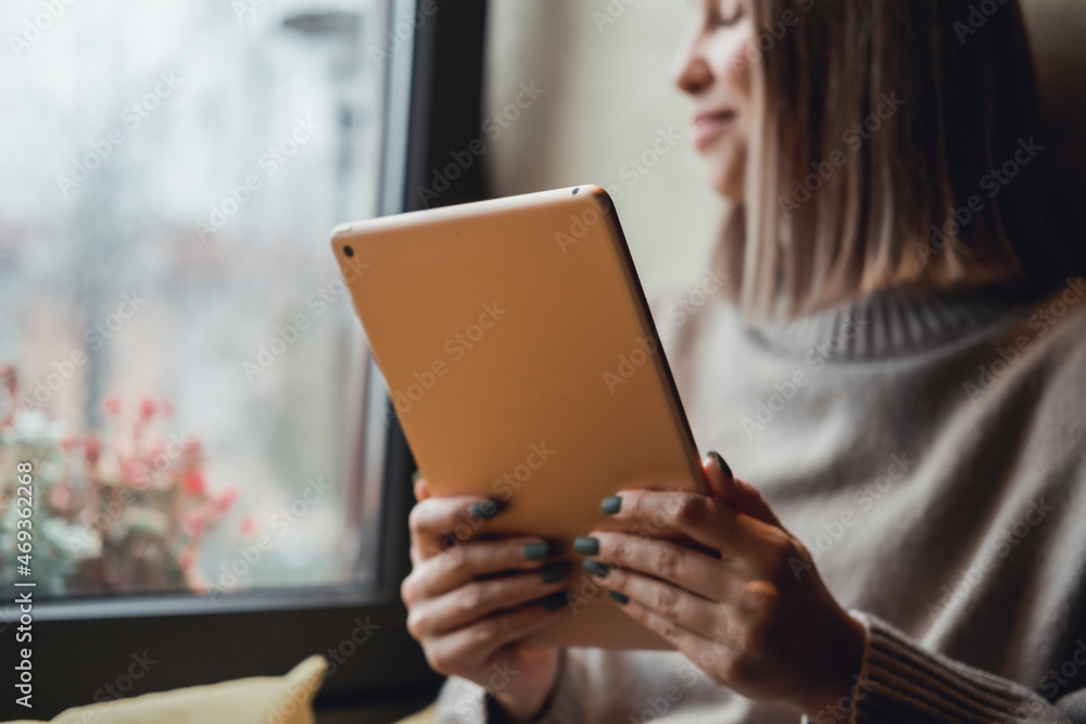 Fototapeta premium Young girl works on the tablet on the internet and goes to the train, ipad surfing, woman using smartphone, holding tablet in hand, send answer texts, travel in train, office manager, hipster