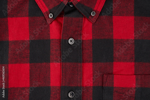 Detailed photograph of a men's flannel shirt in a tartan pattern, showing a portion of the collar and pocket with the centerline and buttons photo