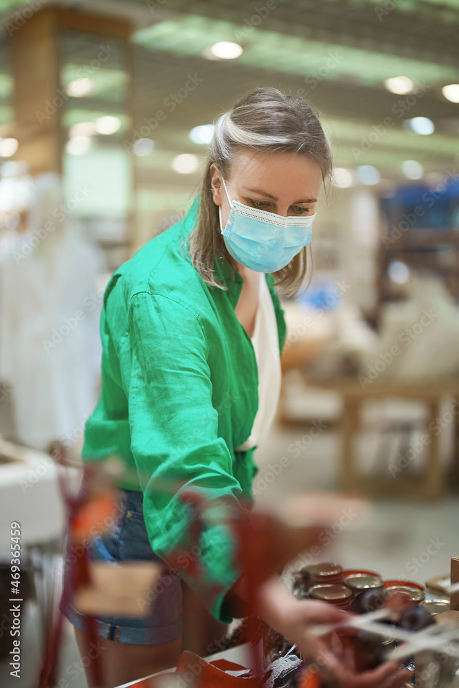 Woman in medical mask in a home decor store.