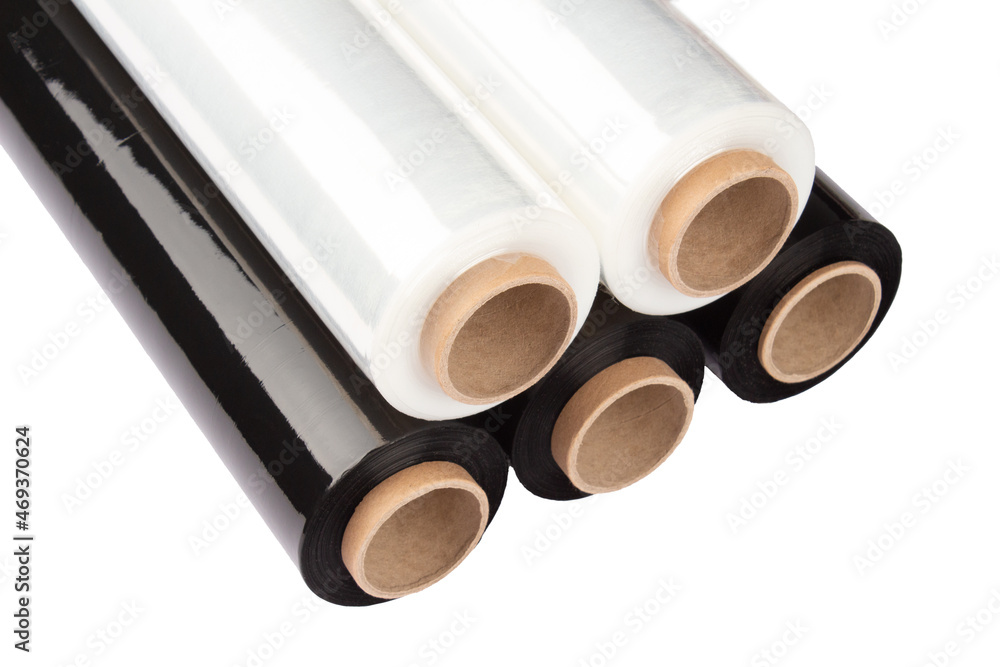 Fototapeta premium Set of plastic packaging materials - plastic white and black stretch film rolls isolated on white. PE packaging materials. Selective focus