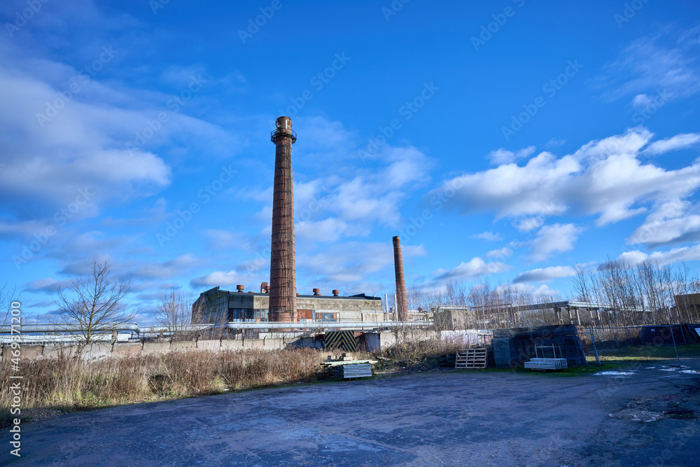 Old factory under the blue sky. Industrial building with chimney made of red brick. High quality photo
