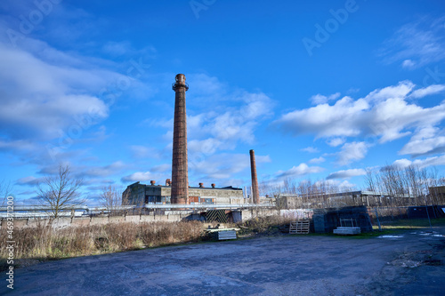 Old factory under the blue sky. Industrial building with chimney made of red brick. High quality photo