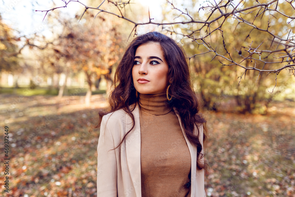 Autumn outdoor. Beautiful girl posing in park, wearing elegant outfit, trees, brown leaves background. Autumn outdoor. Beautiful girl posing in park, wearing elegant outfit, trees, brown leaves background.
