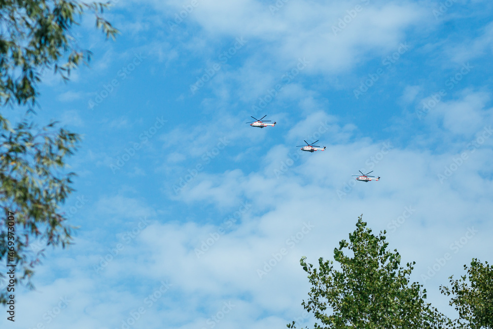 three helicopters are flying against the blue sky three helicopters are flying against the blue sky
