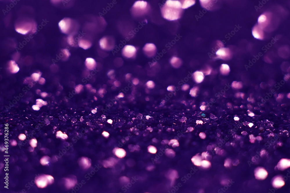 Purple glitter, blurred effect. Glowing holiday light circles are created from bokeh in the camera and lens. Background for design. Christmas background.